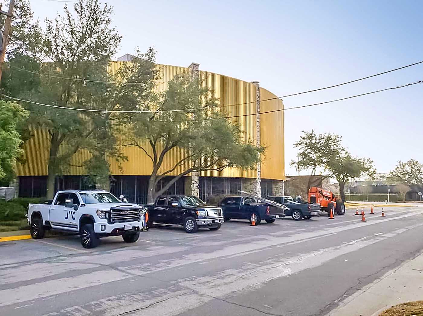 JWC trucks parked along a commercial frontage with a job under way behind them